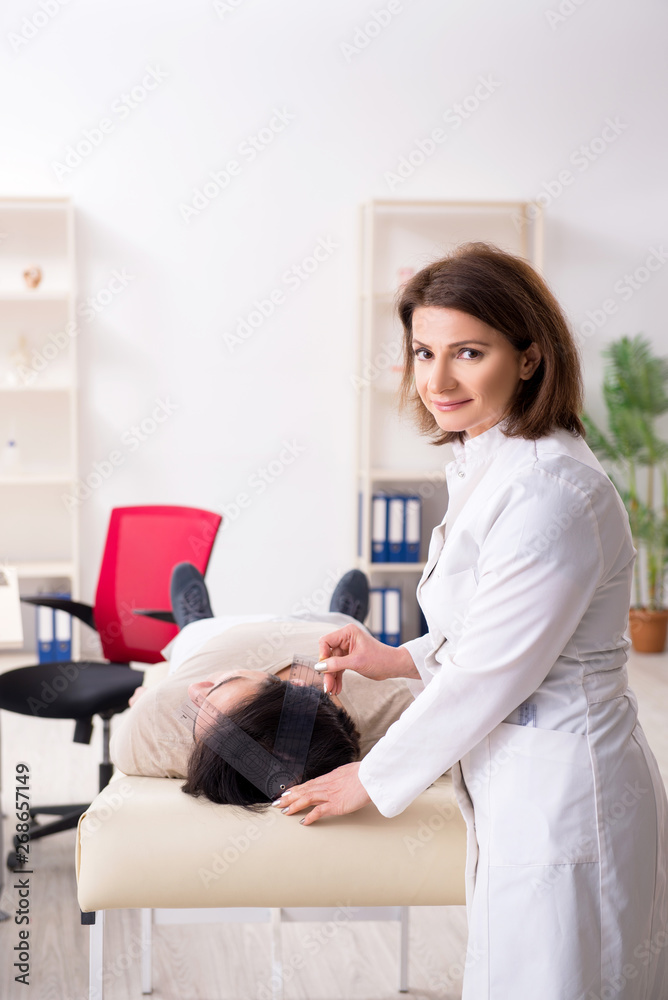 Female doctor checking patient's joint flexibility with goniometer Female doctor checking patient's joint flexibility with goniometer
