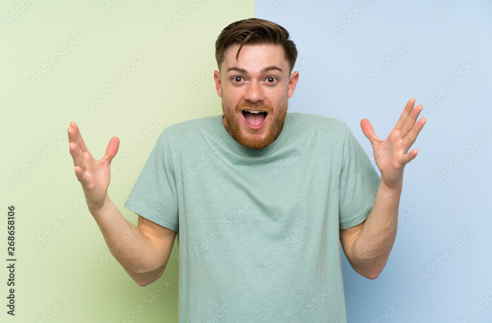 Redhead man over colorful background with surprise facial expression Redhead man over colorful background with surprise facial expression