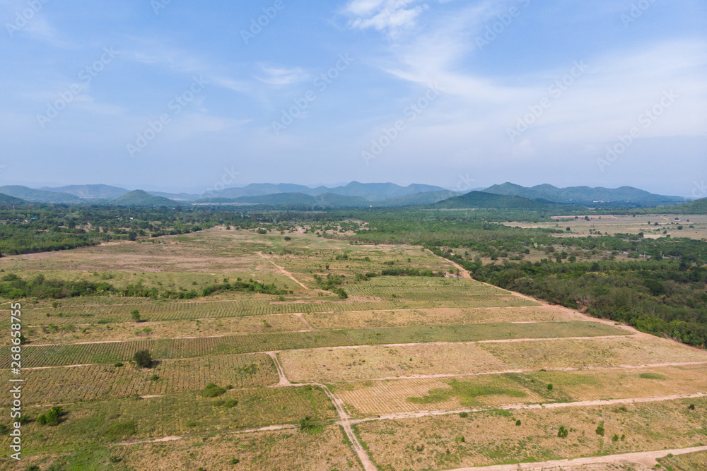 Drone shot aerial view scenic landscape of agriculture farm against mountain and nature forest Drone shot aerial view scenic landscape of agriculture farm against mountain and nature forest