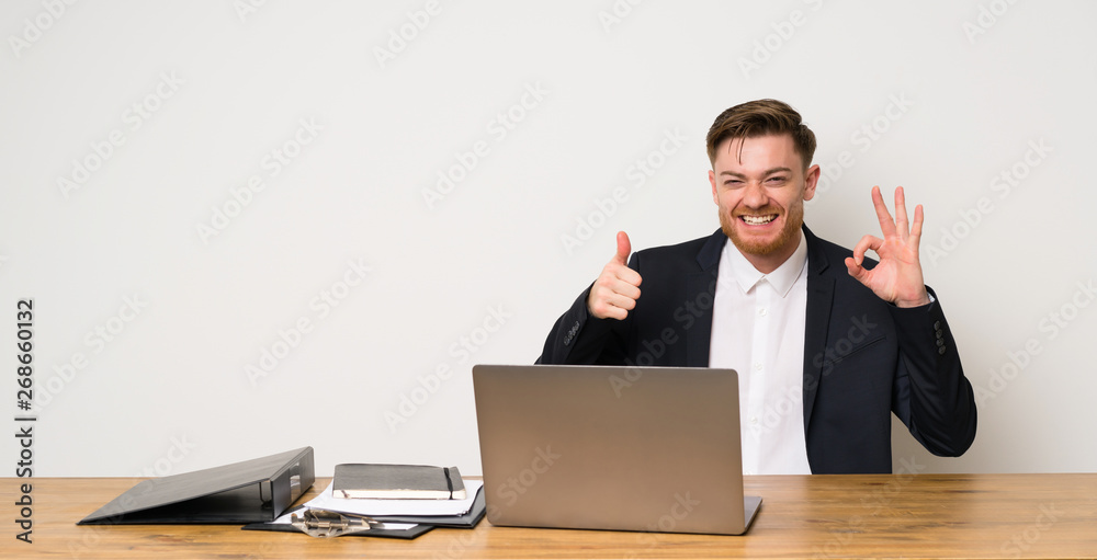 Businessman in a office showing ok sign and thumb up gesture Businessman in a office showing ok sign and thumb up gesture