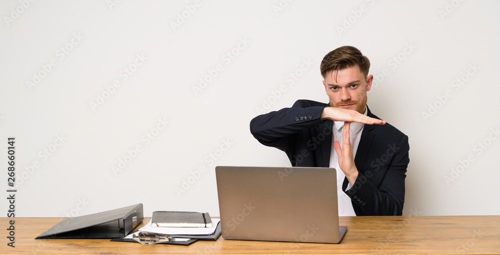 Businessman in a office making time out gesture Businessman in a office making time out gesture