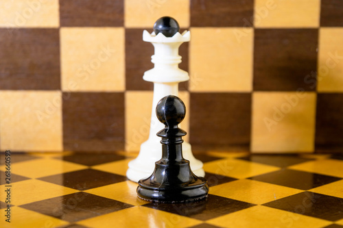 the white chess king and black pawn stand next to a chessboard