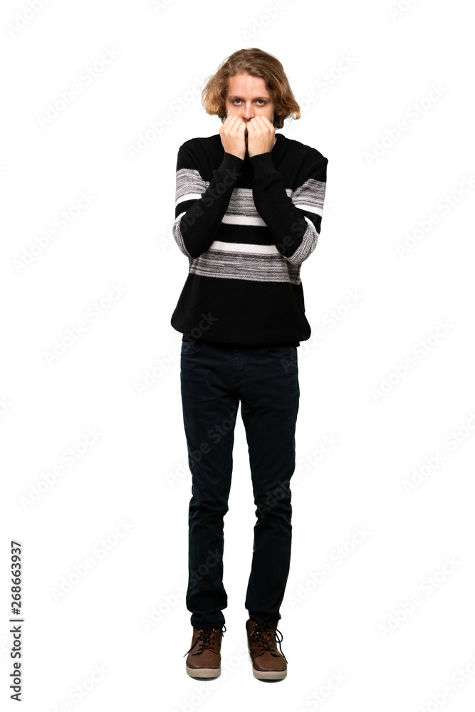 Full-length shot of Blonde man nervous and scared putting hands to mouth over isolated white background Full-length shot of Blonde man nervous and scared putting hands to mouth over isolated white background