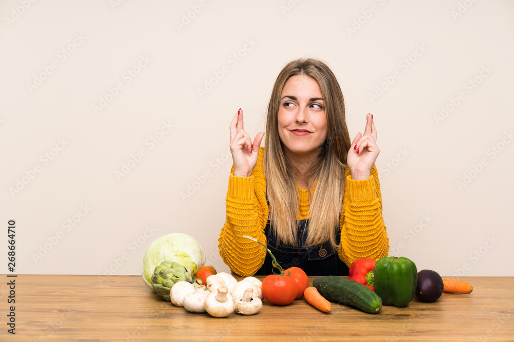 Fototapeta premium Woman with lots of vegetables with fingers crossing