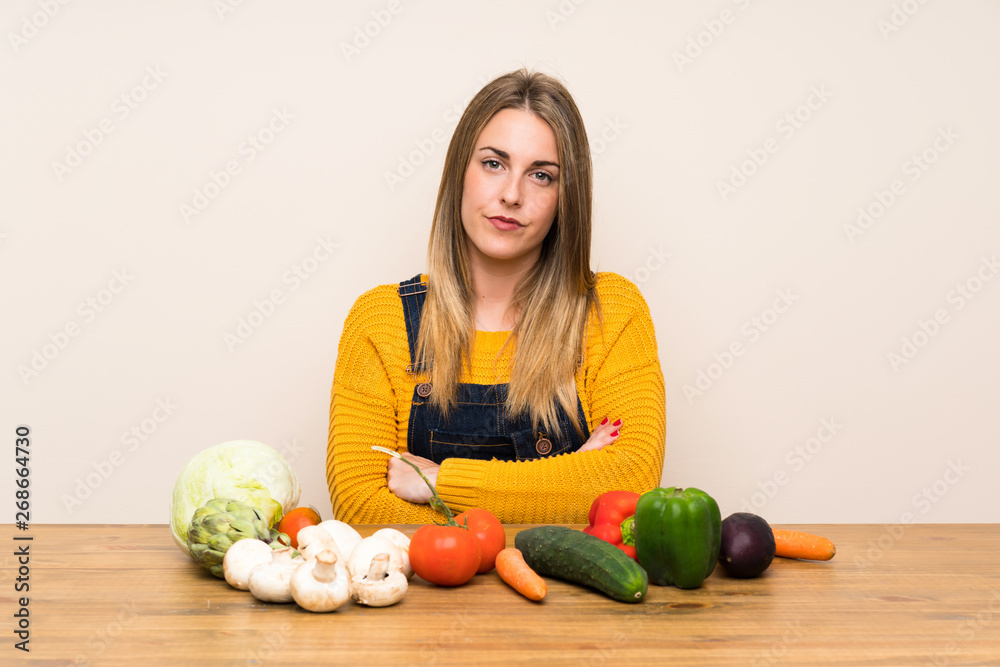 Fototapeta premium Woman with lots of vegetables keeping arms crossed
