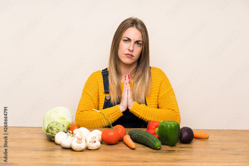 Fototapeta premium Woman with lots of vegetables pleading