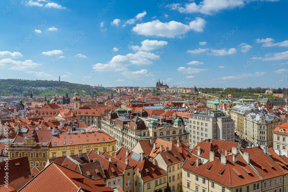 Obraz premium Outdoor sunny panoramic aerial scenery of rooftop in old town, city skyline, Charles Bridge tower and background range of mountain with Prague Castle and St. Vitus Cathedral in Prague, Czech Republic.