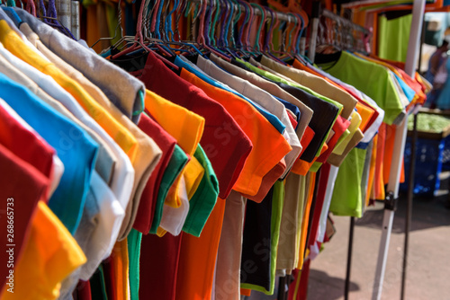 Colorful shirts at a rack on a street market