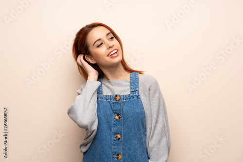 Young redhead woman over isolated background thinking an idea while scratching head