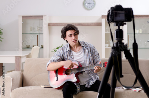 Young guitar player recording video for his blog 