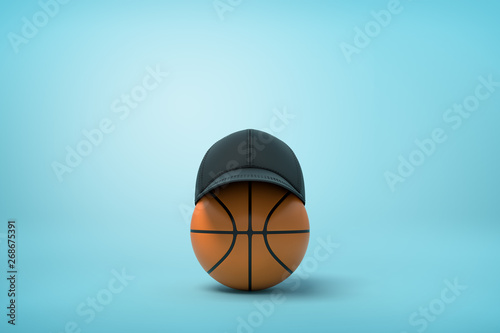 3d rendering of basketball with black baseball cap on top on light-blue background with copy space.
