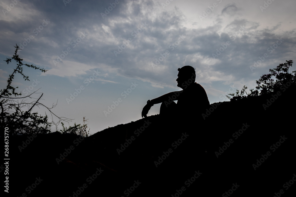 Man sitting shadow with blue sky background showing the state of loneliness