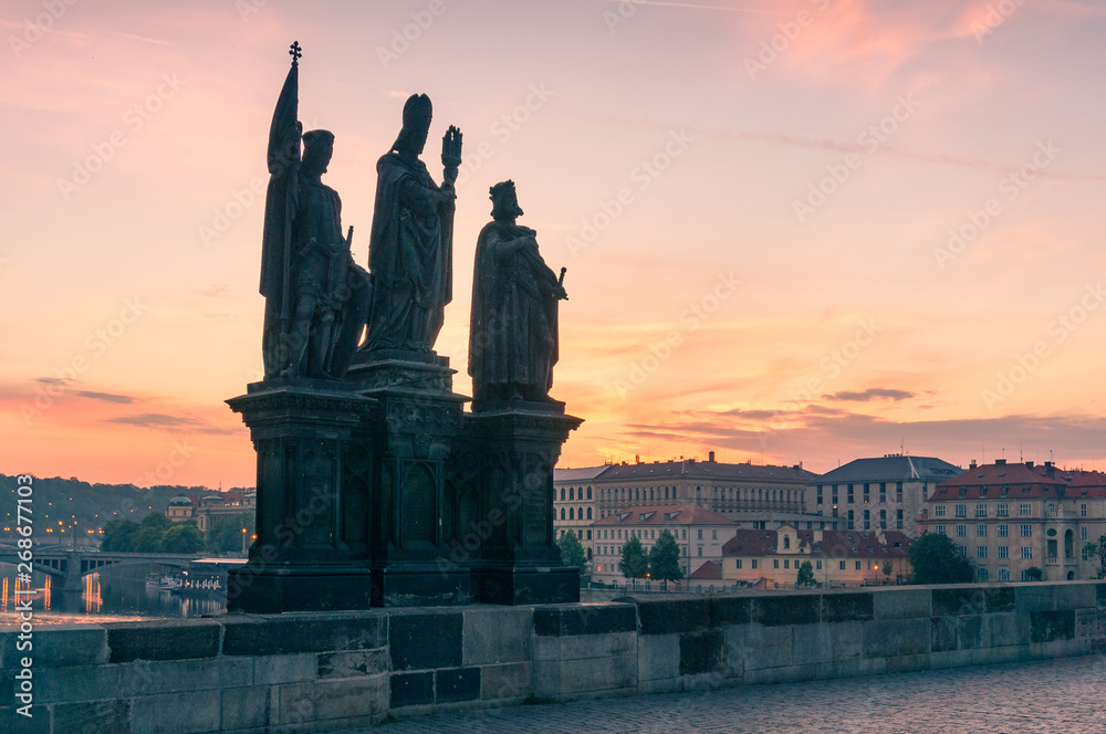 Stone statues at historic Charles Bridge, Karluv Most in Prague at sunrise