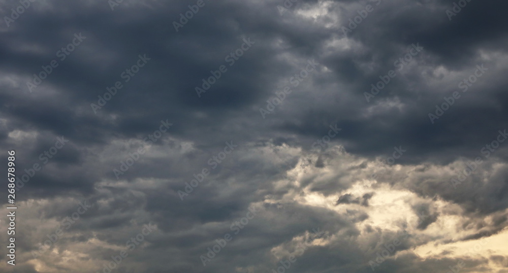 Dramatic dark clouds on blue sky background and texture
