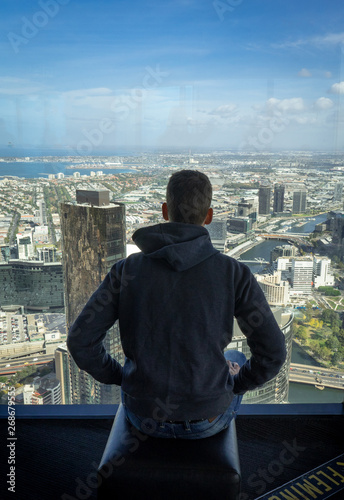 Boy on building with Melbourne city skylin view 