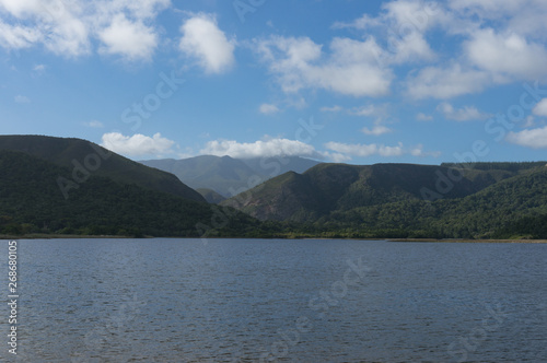 Forest covered mountains and lake in foreground