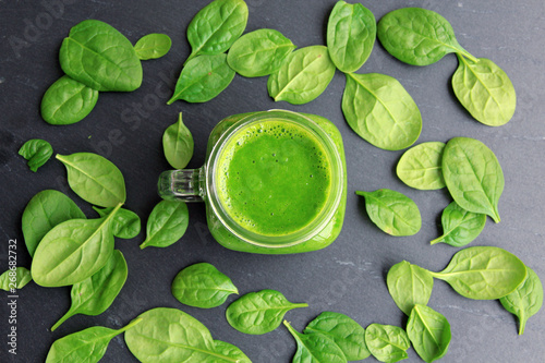 Grüner Smoothie mit Spinat und Obst auf Schieferplatte