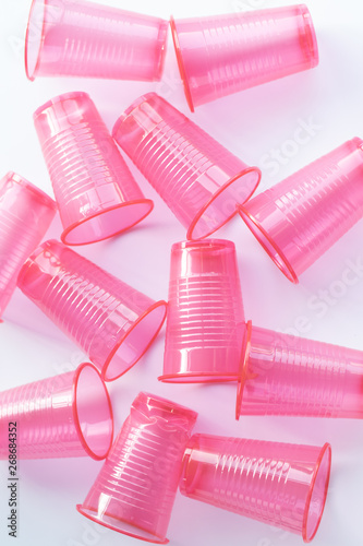 Pink plastic cups on a white background recycling environmental pollution