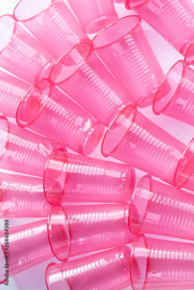 Pink plastic cups on a white background recycling environmental pollution Pink plastic cups on a white background recycling environmental pollution