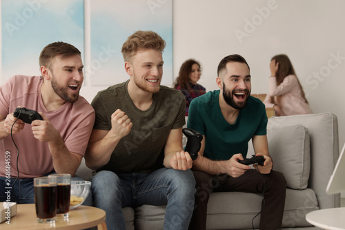 Emotional friends playing video games at home © New Africa