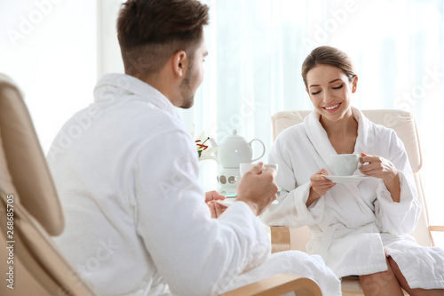 Romantic young couple with tea in spa salon