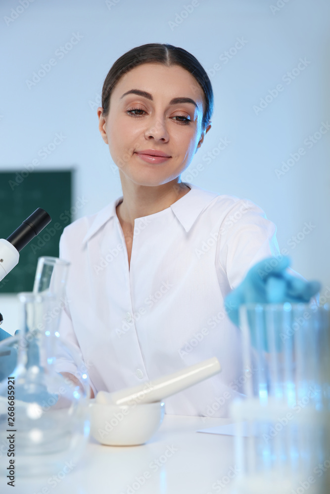 Female scientist working with sample in modern chemistry laboratory Female scientist working with sample in modern chemistry laboratory