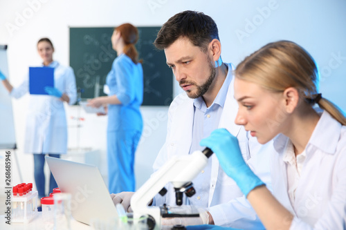 Group of scientists working in modern chemistry laboratory