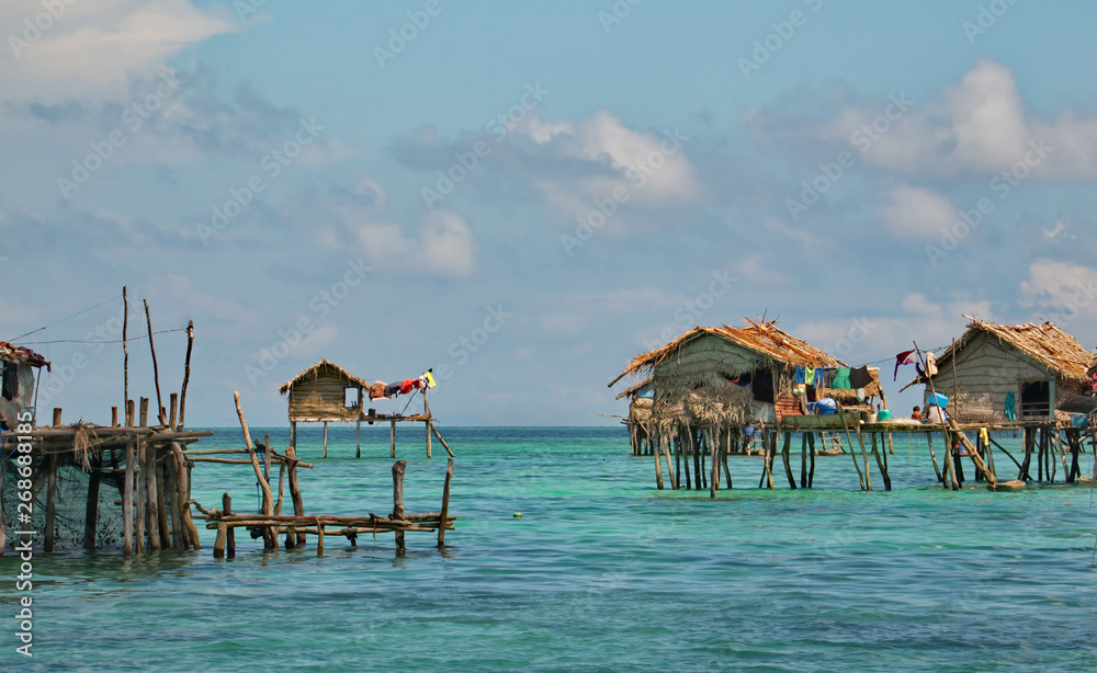 East Malaysia. island of Borneo. Sea Gypsies relax after a night of fishing in a fishing village, whose huts are built on wooden stilts.