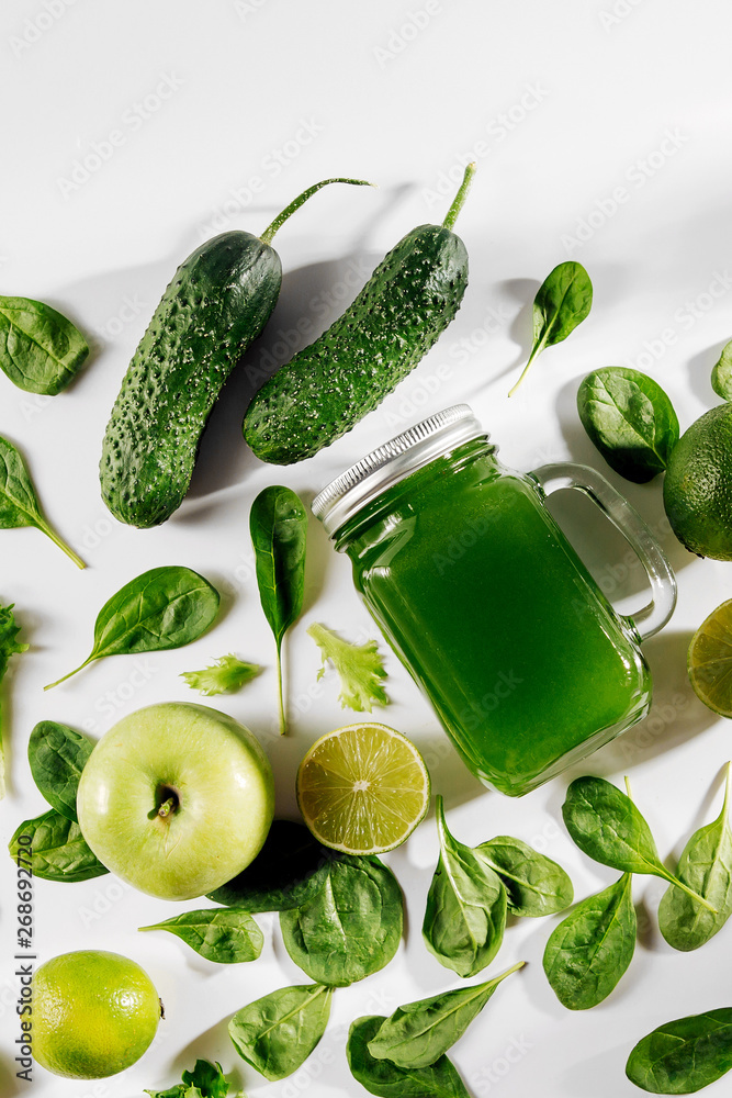 Healthy green vegetable juice with spinach and green fruits and vegetables on white table. Healthy green vegetable juice with spinach and green fruits and vegetables on white table.