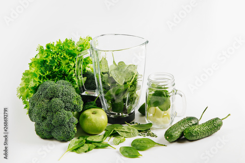 Ingredients for green smoothies in a blender. Healthy food concept with spinach and green vegetables. Vegetarian food.