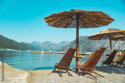 empty beach with sun loungers and umbrellas. sea with mountains