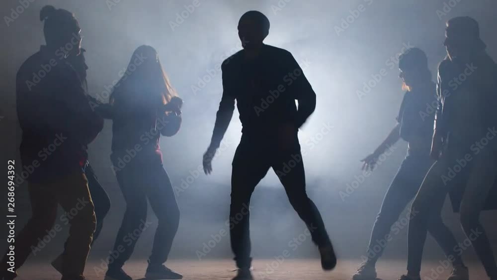 Six Caucasian rappers are performing on dark street. Unforgettable presentation.