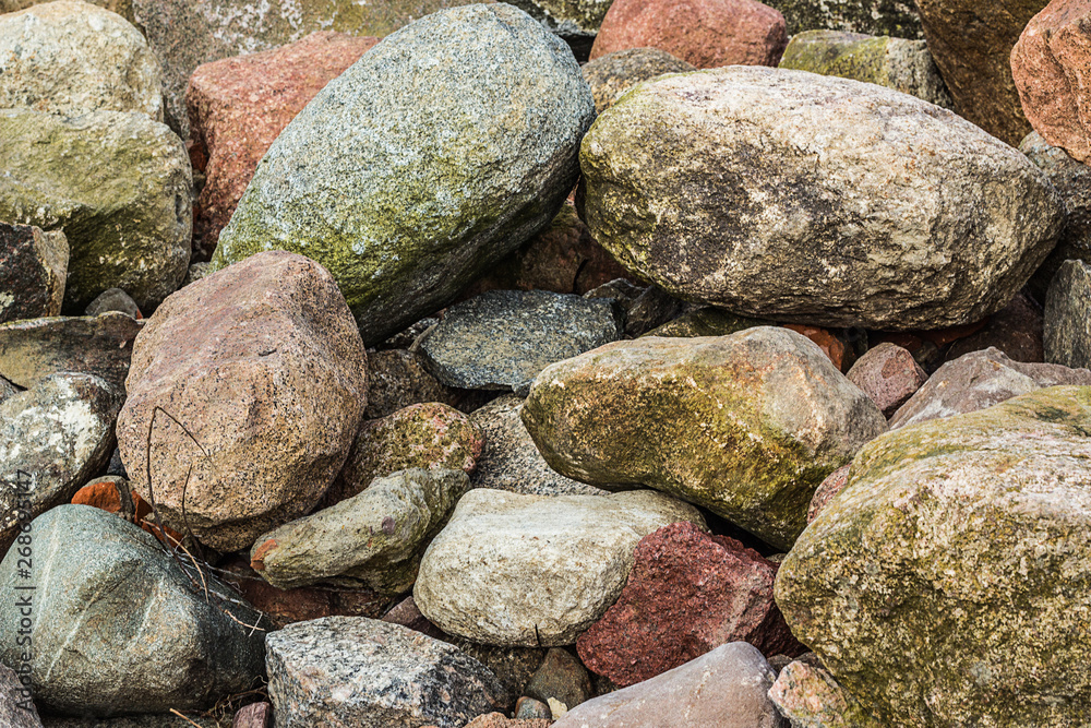 several small and big stones or pebbles on the beach at the baltic sea, a great pattern for a background
