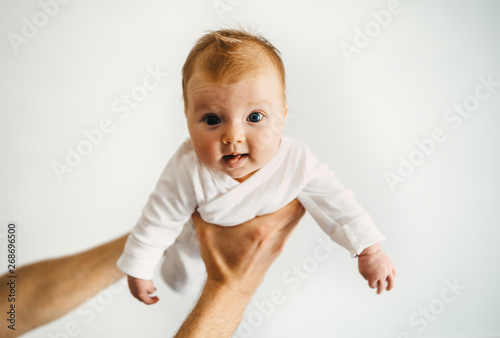 Baby in father hands family lifestyle dad playing with child infant parenthood concept photo
