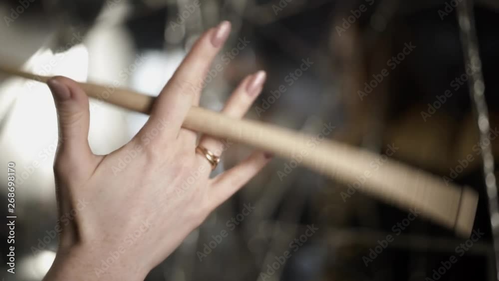 Woman holding drumstick. Action. Closeup of beautiful female hand