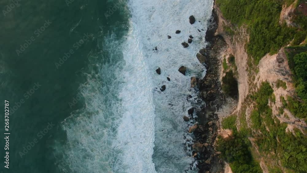 Blue waves in ocean crashing on rock shore. Blue waves in ocean crashing on rock shore.