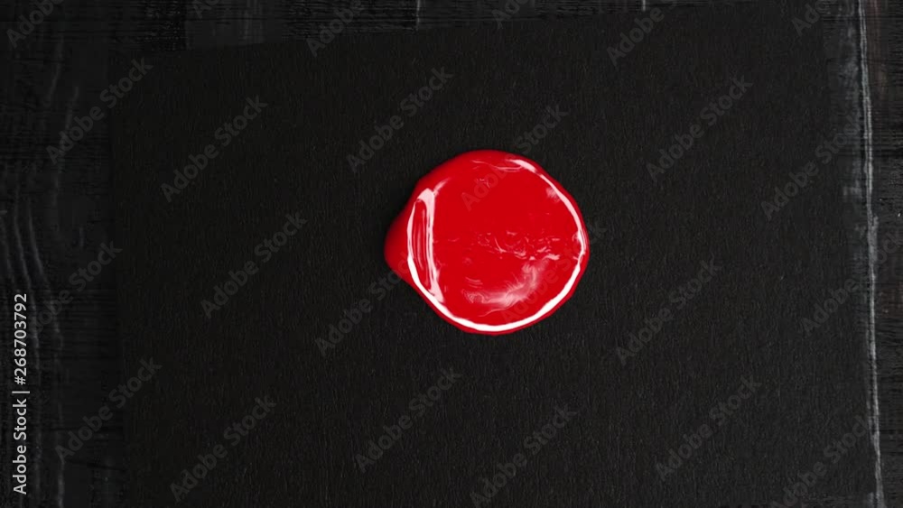 Red wax drop to black paper and golden stamp make a seal
