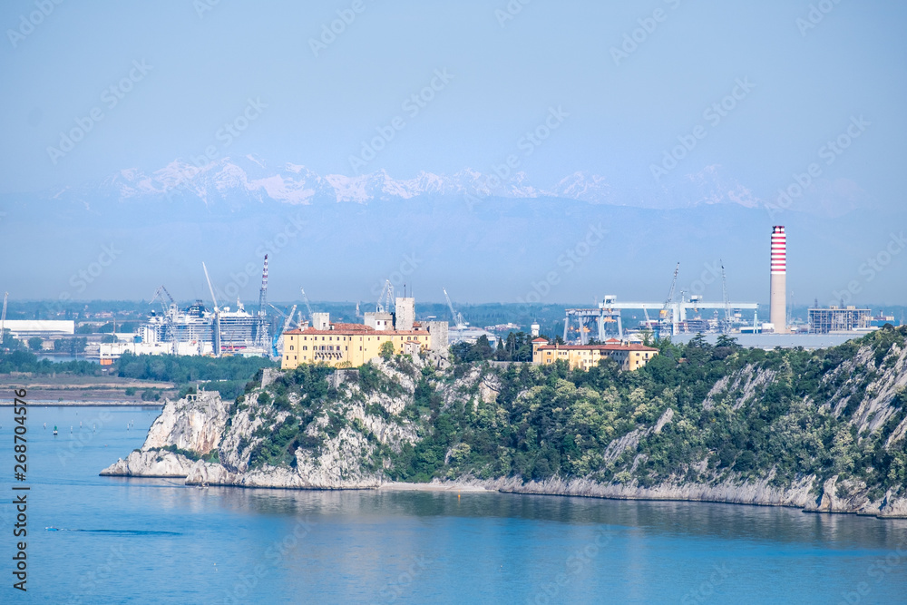Castle Duino and harbor Monfalcone with mountains alps in Italy