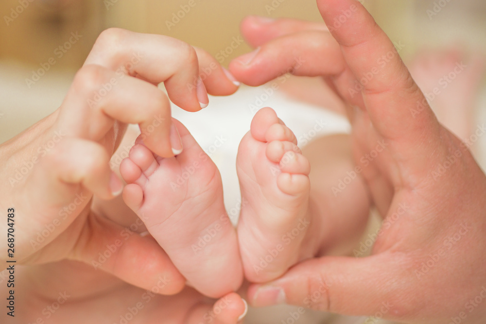 Baby legs heart. Parents holding in the hands feet of newborn baby. Baby legs heart. Parents holding in the hands feet of newborn baby.