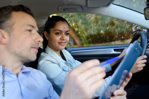 young woman having driving lesson in car
