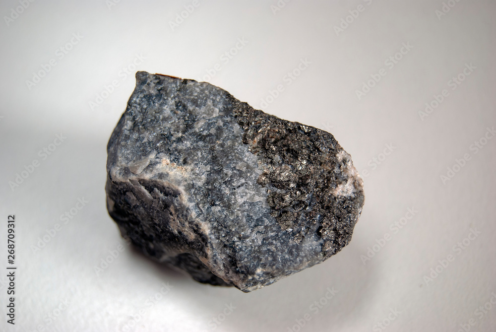 Arsenopyrite specimen (lat. Arsenicum) in the rock on a gray background. Origin: Ural. Arsenopyrite specimen (lat. Arsenicum) in the rock on a gray background. Origin: Ural.