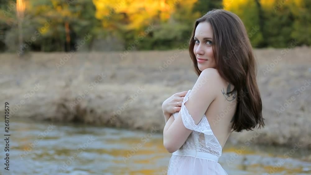 Beautiful girl in a gently pink dress, posing for the camera, on a summer day in nature in the rays of sunset. Beautiful girl in a gently pink dress, posing for the camera, on a summer day in nature in the rays of sunset.