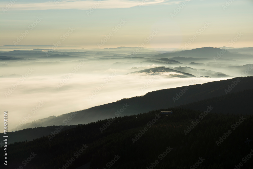 Landscape with inverse cloudiness and protruding peaks of mountains during sunrise. Landscape with inverse cloudiness and protruding peaks of mountains during sunrise.