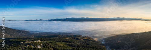 Fotografía Landscape with inverse cloudiness and protruding peaks of mountains during sunrise