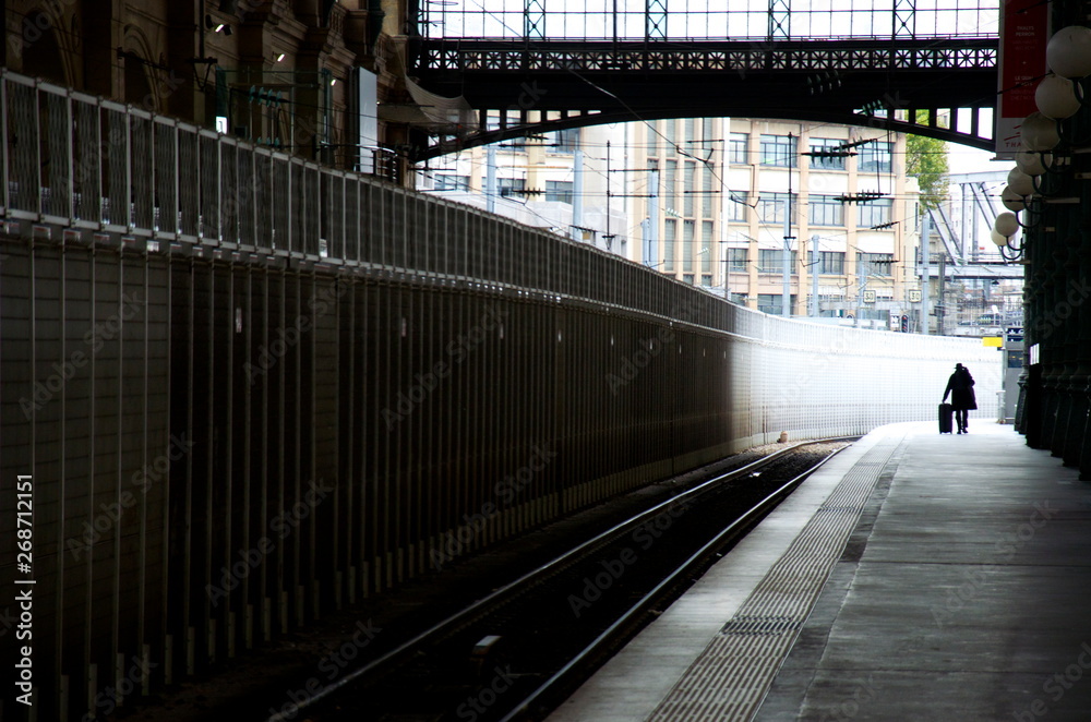 man carrying his luggage trough empty "Gare du Nord" railway station in