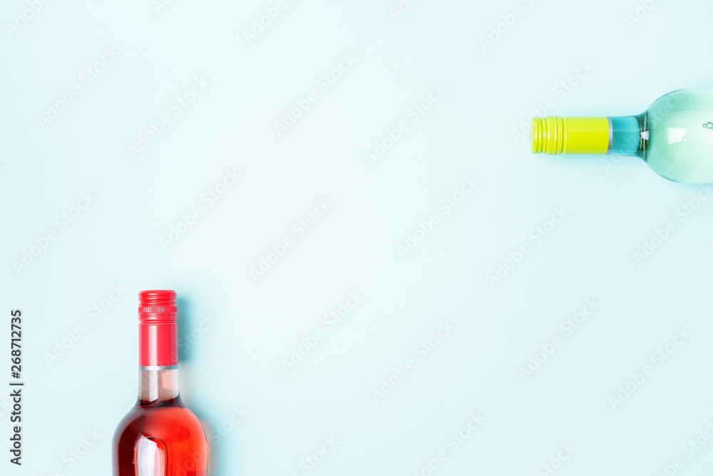 Screw bottle foil caps in different bright colors of white and rose wine bottles on blue background with copy space. Minimal abstract colorful mockup concept of alcohol beverage. Flat lay. Screw bottle foil caps in different bright colors of white and rose wine bottles on blue background with copy space. Minimal abstract colorful mockup concept of alcohol beverage. Flat lay.