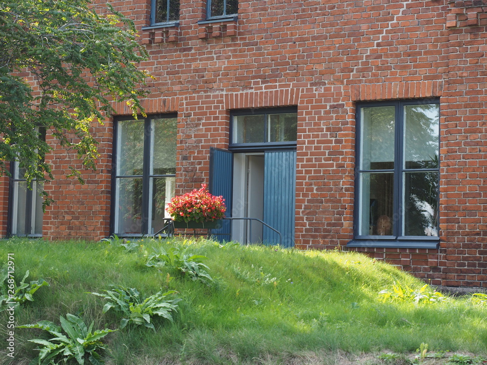  Brick building with large windows and green grass