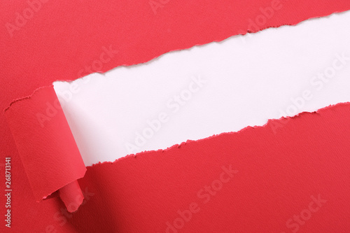 Torn red paper strip curled edge angled diagonal white background