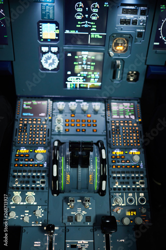 Design of jet airplane cockpit with illuminated buttons, knobs, switches, power levers and displays for determining position in sky, copy space