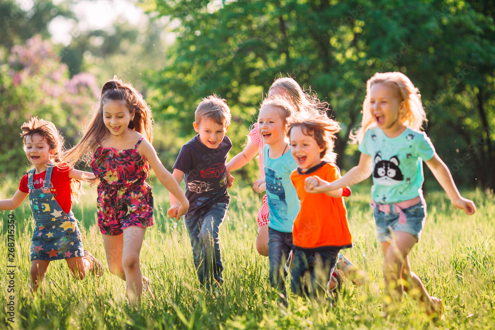 Large group of kids, friends boys and girls running in the park on sunny summer day in casual clothes . - obrazy, fototapety, plakaty 